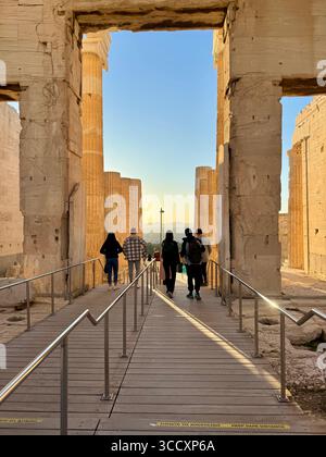 Goldene Stunde Sonnenuntergang am Eingang des Akropolis-Komplexes (Acrópole Propileia) in Athen, Griechenland, mit Touristen, die die Treppe hinunter laufen. Stockfoto
