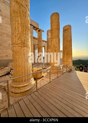 Goldene Stunde Sonnenuntergang am Eingang des Akropolis-Komplexes (Acrópole Propileia) in Athen, Griechenland, mit Touristen, die die Treppe hinunter laufen. Stockfoto