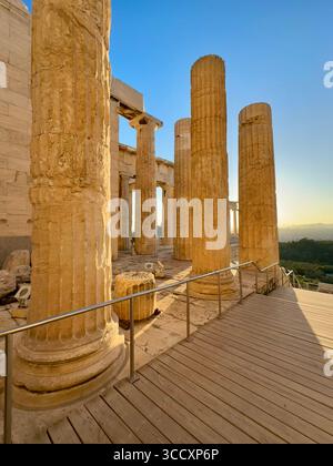 Goldene Stunde Sonnenuntergang am Eingang des Akropolis-Komplexes (Acrópole Propileia) in Athen, Griechenland, mit Touristen, die die Treppe hinunter laufen. Stockfoto