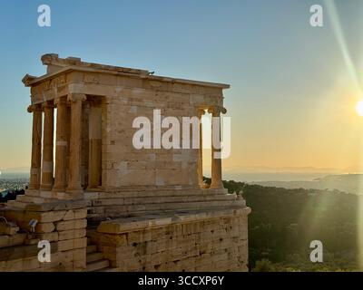 Das Beulé-Tor am Eingang der Akropolis ist bei Sonnenuntergang in warmes, goldenes Stunden-Sonnenlicht getaucht. Stockfoto