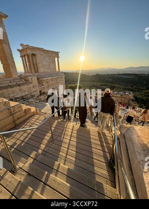Goldene Stunde Sonnenuntergang am Eingang des Akropolis-Komplexes (Acrópole Propileia) in Athen, Griechenland, mit Touristen, die die Treppe hinunter laufen. Stockfoto