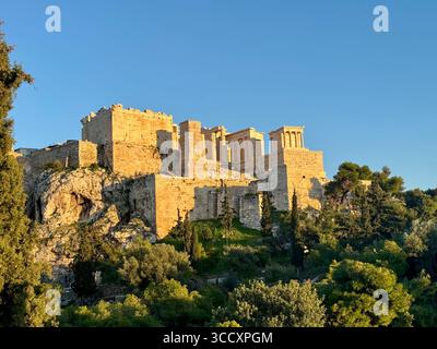 Die Akropolis in Athen, beleuchtet von der goldenen Stunde Sonnenuntergang, mit dem Parthenon und anderen antiken Ruinen deutlich sichtbar. Stockfoto