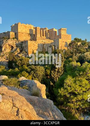 Die Akropolis in Athen, beleuchtet von der goldenen Stunde Sonnenuntergang, mit dem Parthenon und anderen antiken Ruinen deutlich sichtbar. Stockfoto