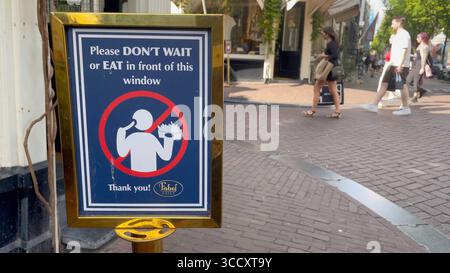 Amsterdam Niederlande 10. August 2025 Ein Schild aus einem Chip-Shop in der Gegend von Negen Straatjes fordert Kunden auf, ihre Waren außerhalb der benachbarten Geschäfte zu verzehren. Die Popularität bestimmter Lebensmittelbetriebe, die durch soziale Medien gefördert werden, hat zu so genannten tiktok-Warteschlangen geführt und andere, die in der Region leben und arbeiten, behindert. Frituur, Pommes, Patat, Ergernis, Essen, Tourismus, Übertourismus, Touristen, Stockfoto