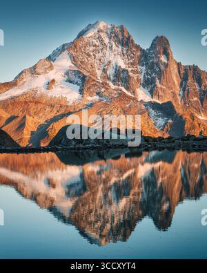 Majestätischer Sonnenuntergang über dem Mont-Blanc-Massiv mit Bergziege auf dem Lac-Blanc-Spiegel in den französischen Alpen in Chamonix, Frankreich Stockfoto