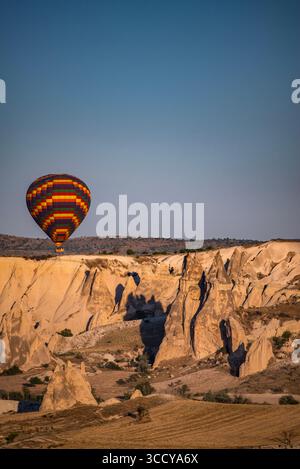 Kappadokien, Türkei: Traditionelle Heißluftballons, die nach Sonnenaufgang am Himmel über dem Tal von Cavusin in der berühmten Region Zentralanatolien schwimmen Stockfoto