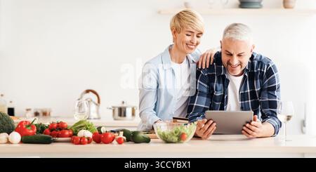 Glückliches Seniorenpaar verwenden Tablette, Kreditkarte, Bestellung der Lieferung von Lebensmitteln im Lebensmittelgeschäft auf dem Markt tun Einkaufen Stockfoto