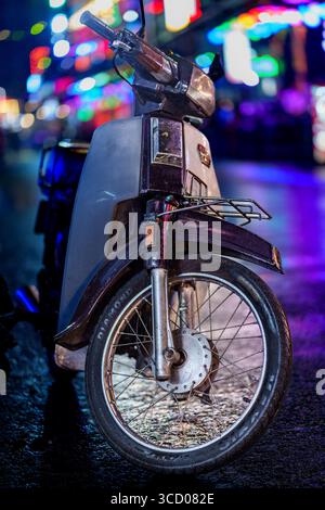 Eine auffällige Nahaufnahme eines Rollers, der auf einer nassen Straße in Bui Vien, Ho Chi Minh City, geparkt wurde, wurde im September 2024 gefangen genommen Stockfoto