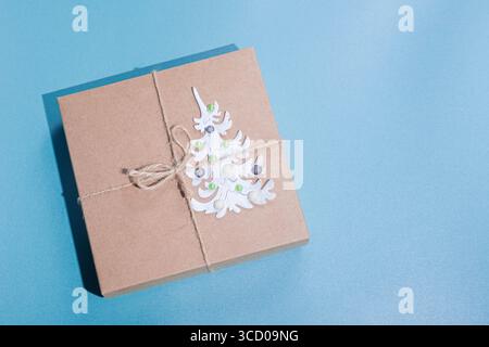 Nahaufnahme Geschenkbox mit Papier-weihnachtsbaum auf blauem Hintergrund dekoriert. Null-Abfall-Konzept. Draufsicht und Kopierbereich Stockfoto