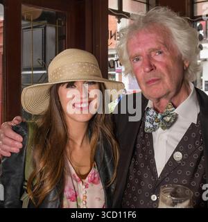 Ein splitternhaariger Mann posiert für ein Foto mit einer jungen Frau während der Bloomsday-Feier in Kennedy's Pub & Restaurant, Westland Row, Dublin, Irland Stockfoto