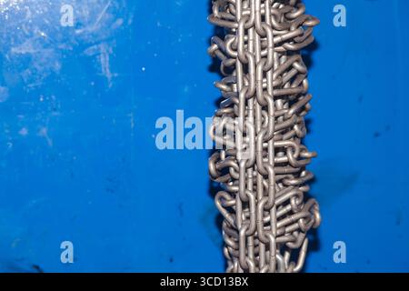 Stahlkette in einem Bündel auf blauem Hintergrund gebunden. Stockfoto