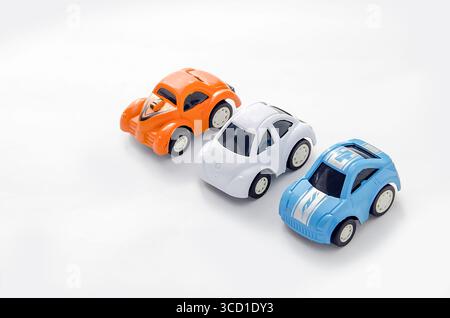 Miniatur-Spielzeugautos in einer Reihe isoliert Stockfoto