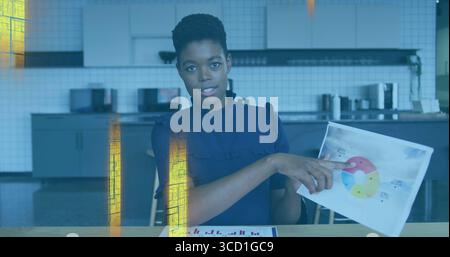 Zeigende Geschäftsfrau in Bluse mit Tortendiagramm in der Küchenzeile des Büros, mit Balkendiagramm Stockfoto