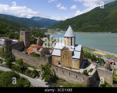 Historische Festung über einem Stausee, umgeben von grünen Hügeln in einer idyllischen Umgebung, aus der Vogelperspektive, Ananuri Castle, Zhinvali Reservoir, Shinvali, Jinva Stockfoto