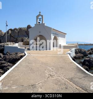Agios Isidoros kleine Kirche, Insel Chios, Griechenland. Traditionelle Architekturkapelle auf einer felsigen Insel, die durch einen schmalen Betonwalkw mit dem Ufer verbunden ist Stockfoto