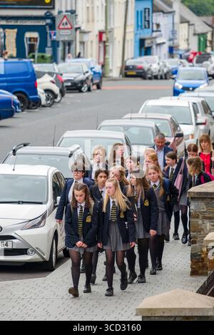 Gruppe von Mittelschüler in Lumen Christi College Uniformen, die auf einem Bürgersteig entlang der Bishop Street, Derry, County Londonderry, Northern IR laufen Stockfoto
