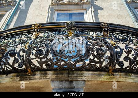 Eleganter, dekorativer, alter schmiedeeiserner Balkon. Detailaufnahme, Blick nach oben, keine Personen Stockfoto
