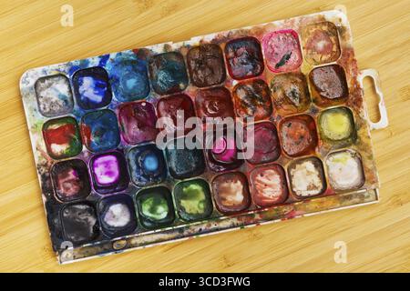 Fertige alte Palette mit Aquarellen, die auf dem Tisch liegen Stockfoto