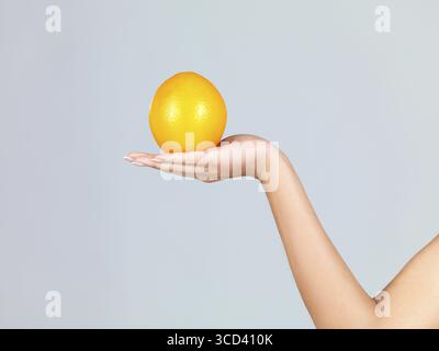 Nahaufnahme der Hand der Frau, sie halten frische orange Stockfoto