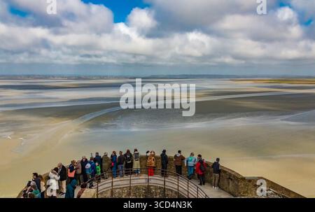 Besucher stehen auf dem Nordturm (Tour du Nord), einem runden mittelalterlichen Wachturm, der auf einem Felsvorsprung entlang der Stadtmauer von Mont-Saint-Michel thront... Stockfoto