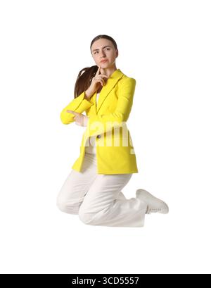 Frau in gelber Jacke, die auf weißem Hintergrund springt Stockfoto