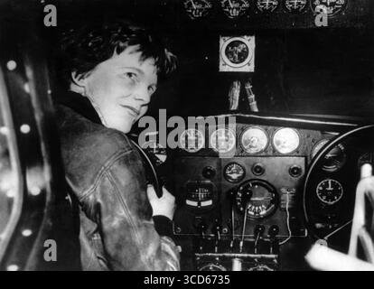 AMELIA EARHART (1897–1937) US-amerikanische Luftfahrtpionierin mit ihrem rechten roten Lockheed 5C Vega im Jahr 1932. Stockfoto