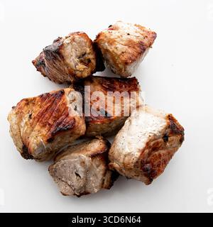 Nahaufnahme von saftigen gegrillten Schaschlik-Stücken aus Schweinefleisch, isoliert auf weißem Hintergrund, perfekt für Grillpicknicks und Themen der traditionellen Küche Stockfoto
