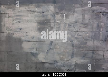 Schmutzig lackierte Betonwand Hintergrund in Grautönen Stockfoto