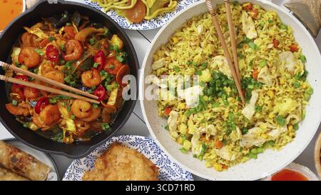 Chinesisches Essensset. Chinesische Nudeln, gebratener Reis mit Hühnchen, Garnelen, Frühlingsrollen, frittiertes knuspriges Hühnchen. Draufsicht. Asiatisches Speisenkonzept Compo Stockfoto