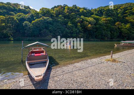 Traditionelle japanische Flachbodenboote auf den Schotterufern des Katsura River am Hozugawa River Boat Ride Destination Point, Sagatenryuji Su Stockfoto