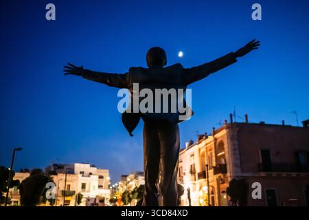 Silhouette der Statue von Domenico Modugno in Polignano eine Stute bei Nacht mit dem Mond im Hintergrund, Apulien, Italien Stockfoto