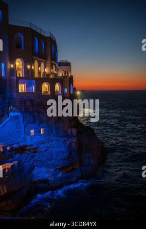 Restaurant Grotta Palazzese und Küste bei Sonnenuntergang, Polignano a Mare, Italien Stockfoto