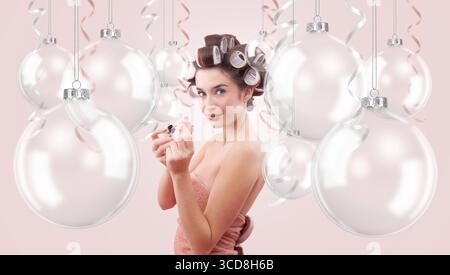 Weihnachtsschmuck. Frau, die nagellack aufträgt, umgeben von transparenten Weihnachtsschmuck. Werbebanner für Feiertage mit Copy Spa Stockfoto