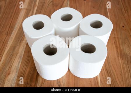 Weiße Toilettenpapierrollen für Hygiene auf dem Holztisch. Toilette. Stockfoto