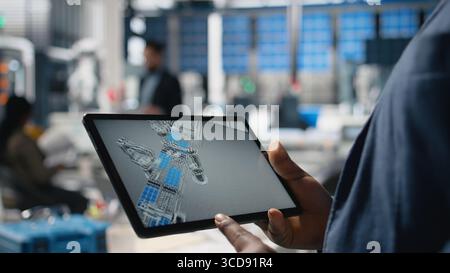 Solarstromtechniker überprüft Daten auf Tablets in einer Photovoltaik-Fabrik, überprüft die Leistung der Produktionsanlage und die Produktionslinie auf Solarinnovationen. Alternative Energie. Kamera A.. Stockfoto