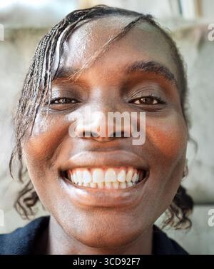 Perfekte Zähne, wie Ihr Zahnarzt die Gesundheitsgeschichte erzählt, lächelnde einzelne afrikanische Frau mit einem großen zahnigen Lächeln Stockfoto