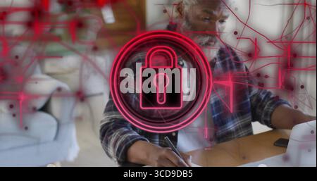 Tippmann in kariertem Hemd, der im Wohnzimmer am Laptop arbeitet, mit neonfarbenem Vorhängeschloss Stockfoto