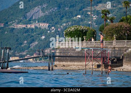 Mann, der auf einem Tauchbrett und einer Plattform über dem Comer See im Grand Hotel Villa Serbelloni, Bellagio, Provinz Como, Lombardei, Italien steht Stockfoto