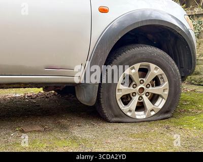 Fahrzeug mit flachem Vorderreifen. Reifenpanne Stockfoto