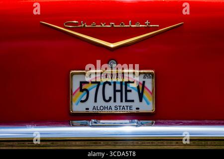 Kräftig rot 1957 Chevy Bel Air parkte im Sonnenlicht und präsentierte sein Chrom und seine Kurven. Eine zeitlose amerikanische Autokultur mit Nostalgie und Vintage Stockfoto