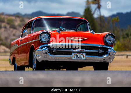 Kräftig rot 1957 Chevy Bel Air parkte im Sonnenlicht und präsentierte sein Chrom und seine Kurven. Eine zeitlose amerikanische Autokultur mit Nostalgie und Vintage Stockfoto