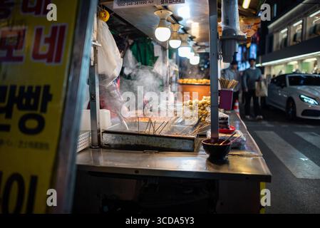 Am 15. März 2024 gibt es einen belebten koreanischen Street Food-Stand mit Spießen und dampfenden Gerichten im Bezirk Hongdae in Seoul, Südkorea Stockfoto