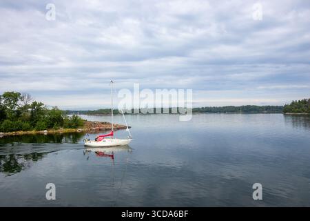 Ruhige nautische Szene, in der Segelboote mit ihrem Motor über ruhiges Meer fahren, Segel im Golf von Finnland, Ostsee, Schweden, Sommerurlaub Stockfoto