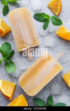 Fruchtorangeneis, Eiswürfel und Scheiben von Zitrusfrüchten. Stockfoto