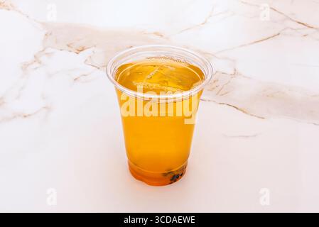 Sommer-Klassiker: Frisch gebrühter Eistee mit einem Hauch Honig, serviert in einem mattierten Glas mit Kondensationsüberzug, das zum Schlucken einlädt Stockfoto