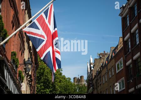 Die Flagge der Union Jack auf einem Fahnenmast vor einem klaren blauen Himmel steht für die nationale Identität, den Stolz und das Erbe des Vereinigten Königreichs. Stockfoto