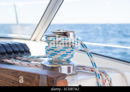 Segelbootswinde auf einem Segelboot und Seile an Stoppern, Line Jammer. Details zum Yachting auf einem Segelboot. Stockfoto