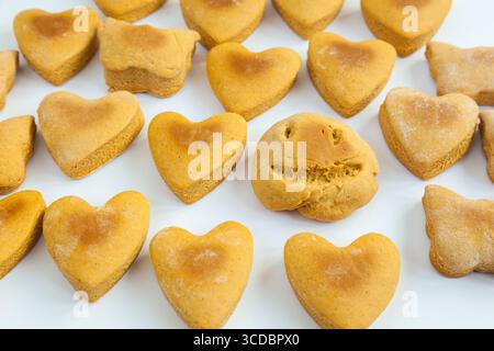 Hausgemachte Kekse in Form von Herzen und Gesicht auf einem weißen Teller. Stockfoto