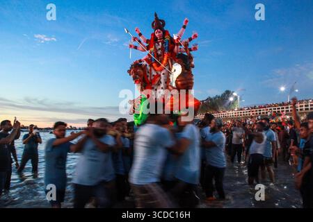 Chittagong, Bangladesch - 5. Oktober 2022: Blick auf ein lebendiges Durga-Idol, das während des Tauchens ins Wasser getragen wird, mit Menschenmassen entlang der Sea Beach Road. Stockfoto