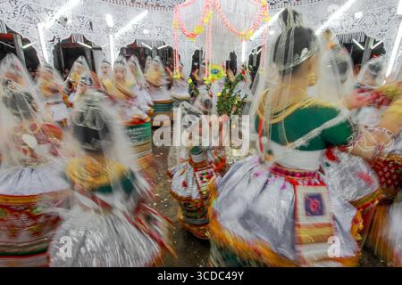 Sylhet, Bangladesch - 08. November 2022: Blick auf anmutige Tänzer in traditioneller Kleidung, deren Bewegungen in einem lebendigen Spektakel aus Farben und Licht unter kunstvollen Dekorationen verschwimmen. Stockfoto